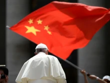 A worshiper waves the flag of China as Pope Francis leaves following the weekly general audience on June 12, 2019, at St. Peter's Square at the Vatican.