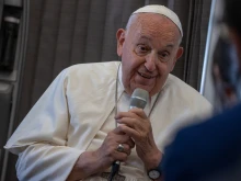 Pope Francis speaks to journalists aboard the papal plane during an in-flight press conference on Friday, Sept. 13, 2024, on his return from his nearly two-week tour of Southeast Asia.